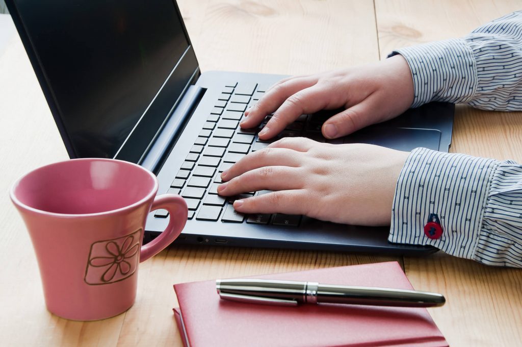 Businesswoman typing on laptop computer, managed IT concept