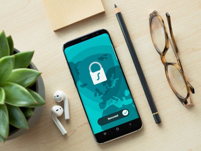 Mobile phone on desk with “secured” image of padlock, cybersecurity concept