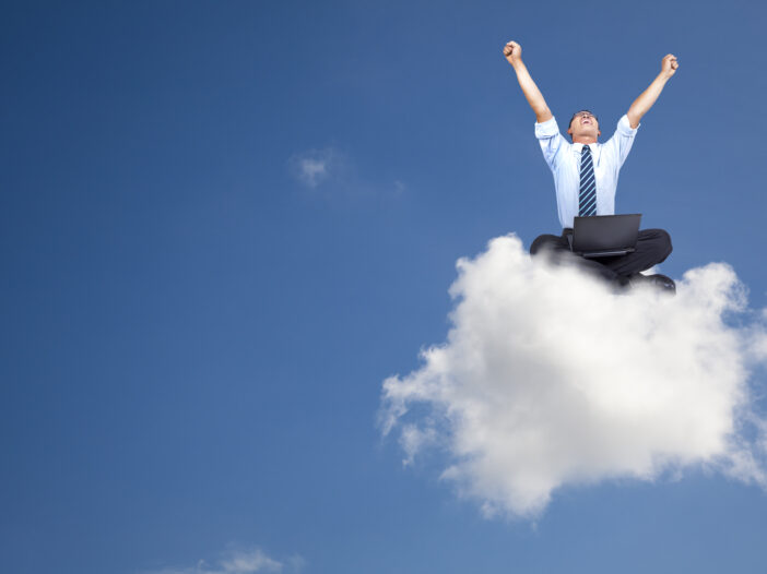 Excited man sitting on a cloud with computer