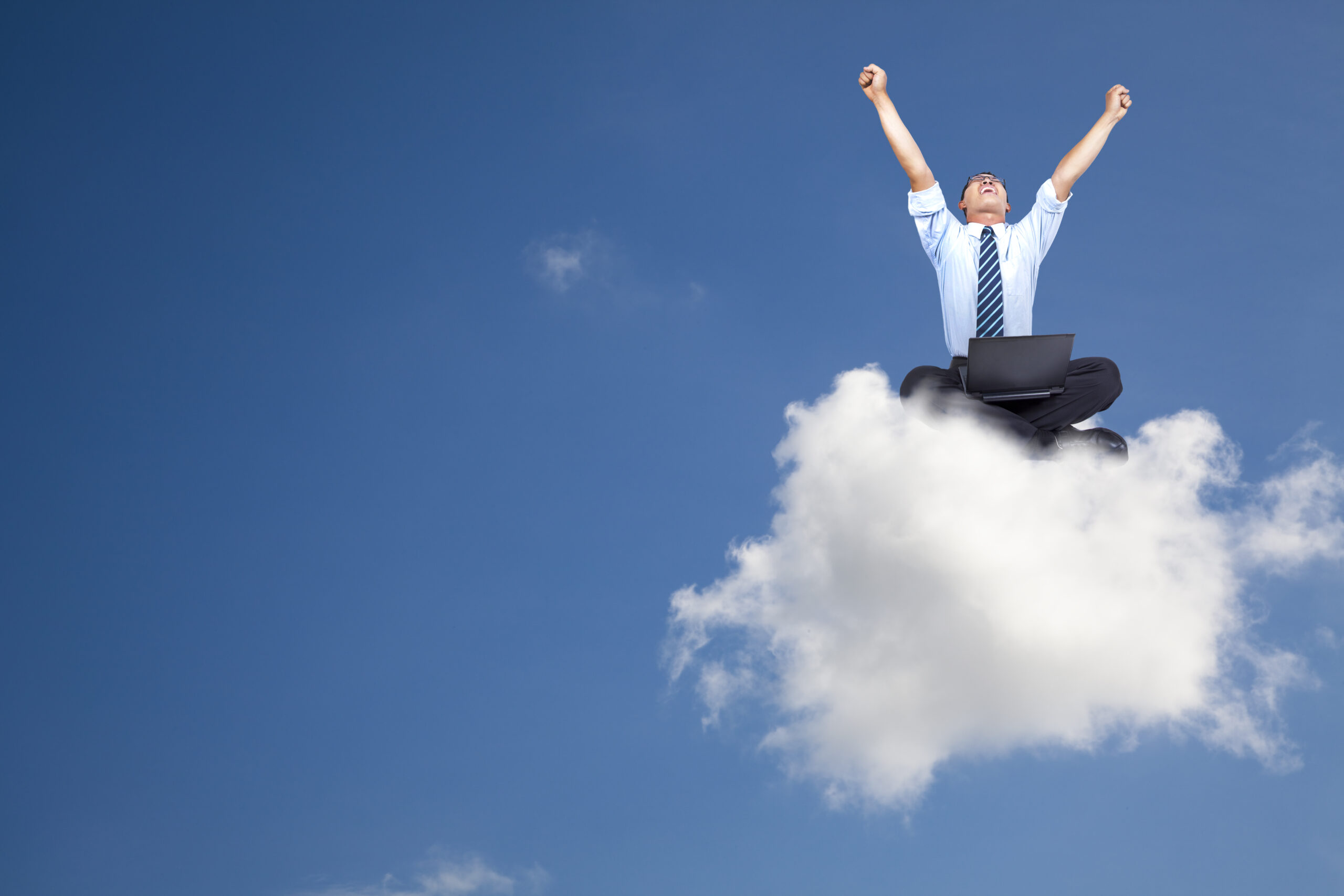 Excited man sitting on a cloud with computer