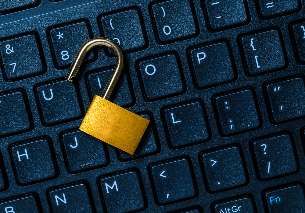 An open lock on a keyboard showing the importance of using cybersecurity to secure your business.